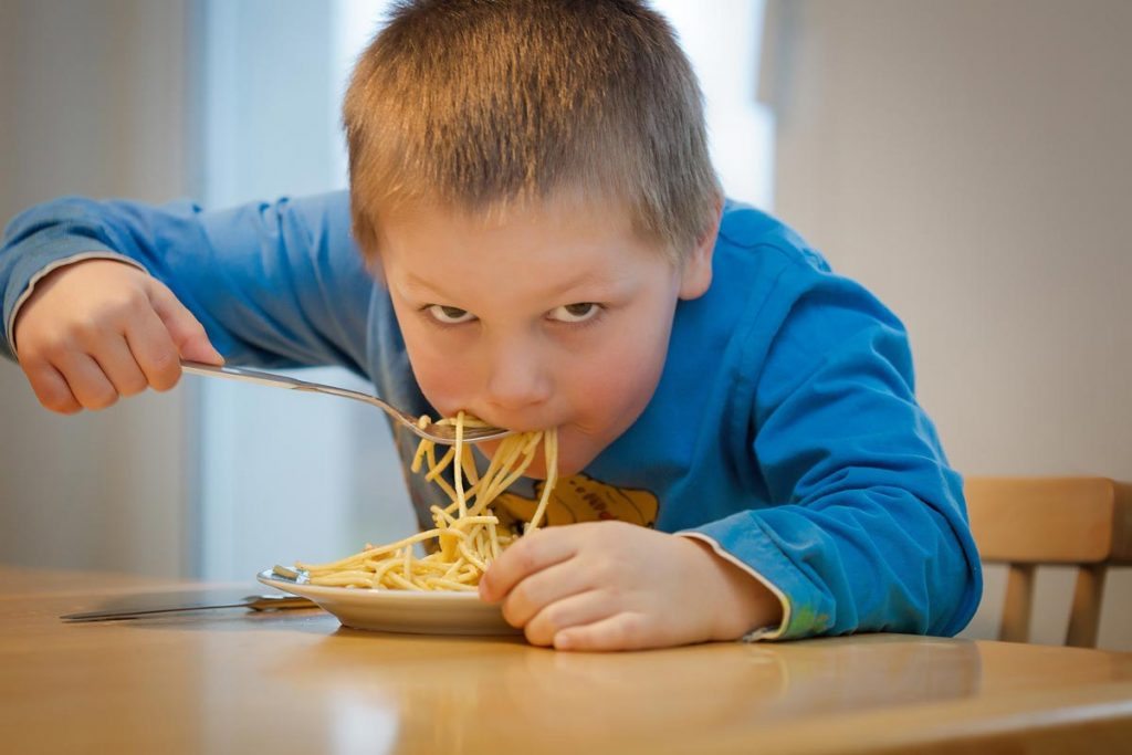 Kid eating noodles.