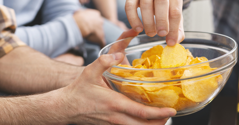 Bowl of crisps being shared.